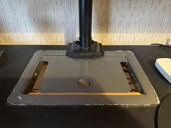 Tämä on kuva pöydästä, jossa on laitteiden ja kaapeleiden seassa metallinen pöytätaso.