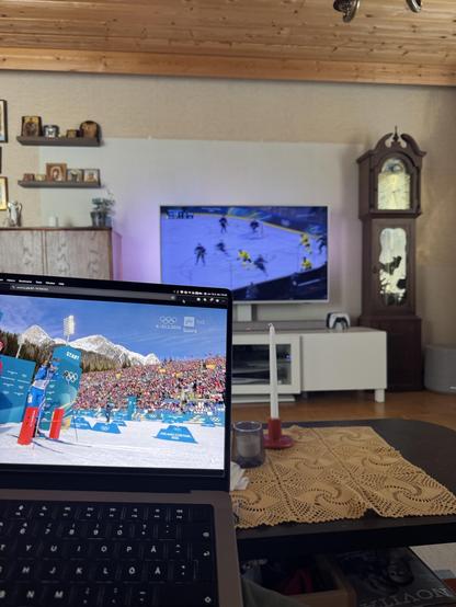 Olohuoneessa katsotaan yhtä aikaa televisiosta jääkiekkoura ja kannettavalta ampumahiihtoa.