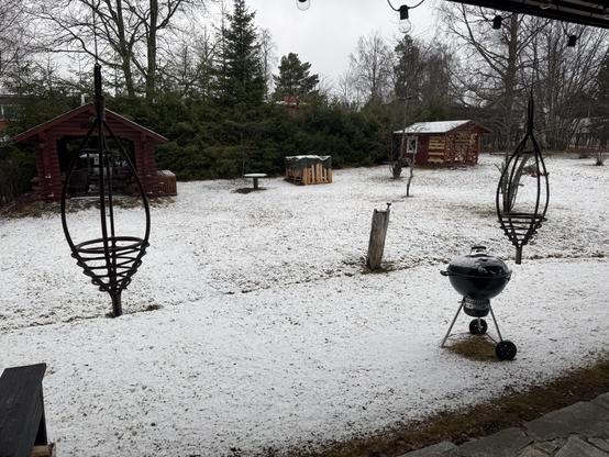 Luminen takapiha jossa grillejä, grillikatos sekä leikkimökki.