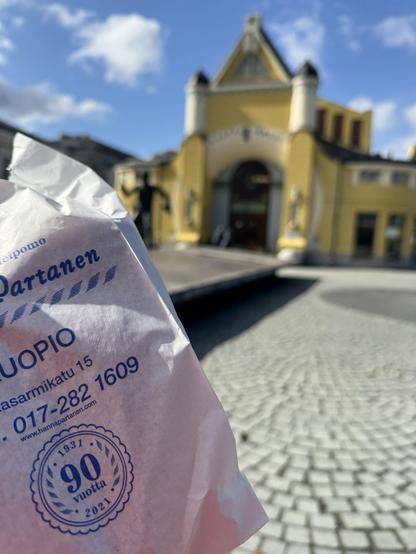 Hanna Partasen lihapiirakka ja taustalla näkyvä Kuopion kauppahalli.