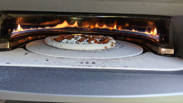 Pizza pyörivässä pizza uunissa.